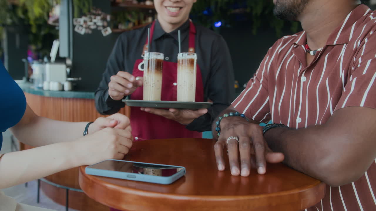 Waiter Brining Drinks to Couple during Business Lunch