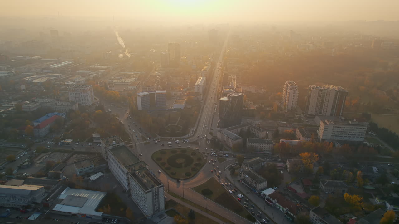 Aerial drone view of Chisinau at sunrise, Moldova. View of the city with fog in the air, multiple buildings, streets with yellowed trees