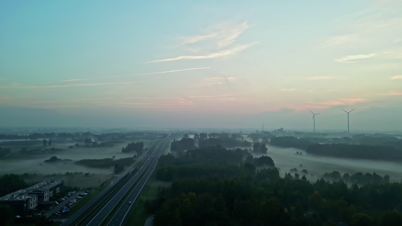 배경에 풍력 터빈과 함께 안개 아침에 도로의 대기 풍경