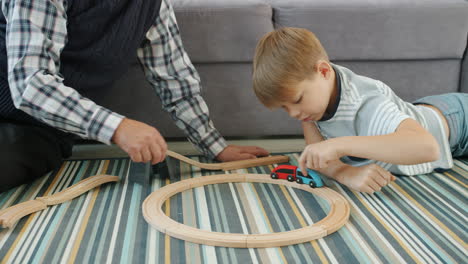 grandfather and grandson playing with toy train