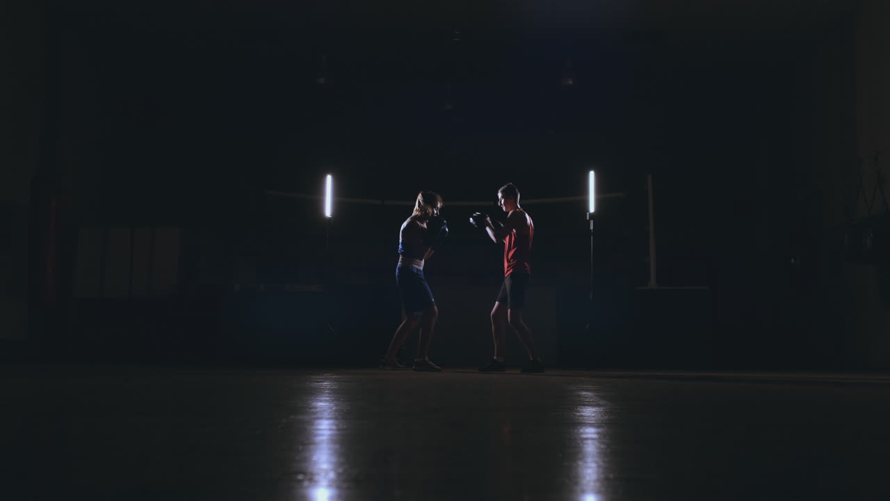 kickboxer mujer atleta entrenadora de kickboxing entrenando amigas de acondicionamiento físico boxeando golpeando guantes de enfoque disfrutando de un entrenamiento intenso juntos en el gimnasio de cerca