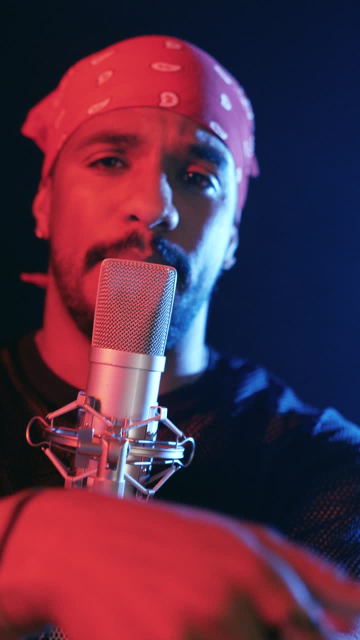 Young rapper singing into a condenser microphone. Vertical