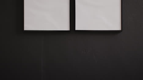 black wooden frames with copy space on white background against black wall