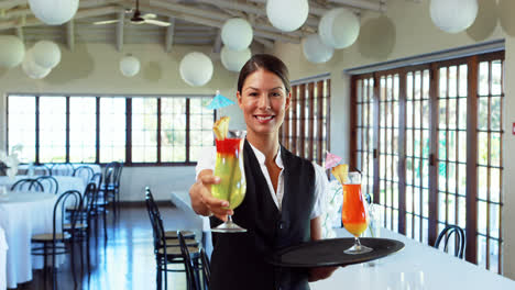 smiling waitress offering a cocktail drink