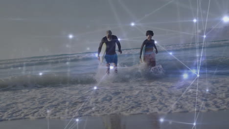 man and woman carrying surfboards running through waves with network overlay showcasing technology