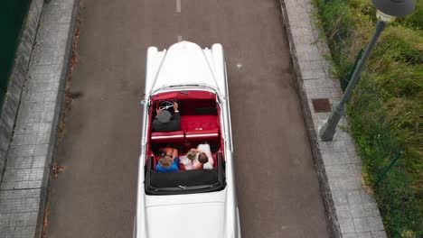 aerial shot of a bride and her mother in a vintage luxury car