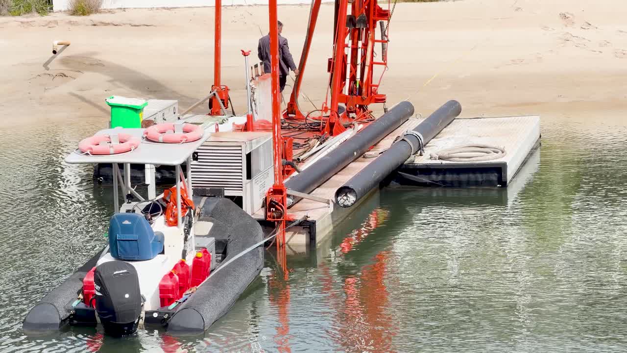 Un uomo esegue la manutenzione su un motoscafo ormeggiato in un canale soleggiato sul lungomare della Gold Coast