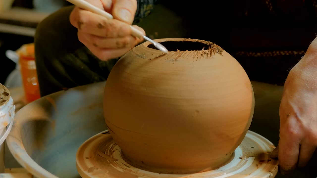 taza de tallado de alfarero profesional con herramienta especial en taller de cerámica