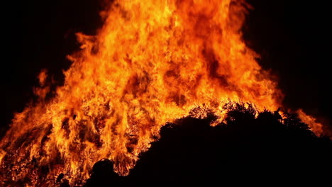 a large bonfire burns at night