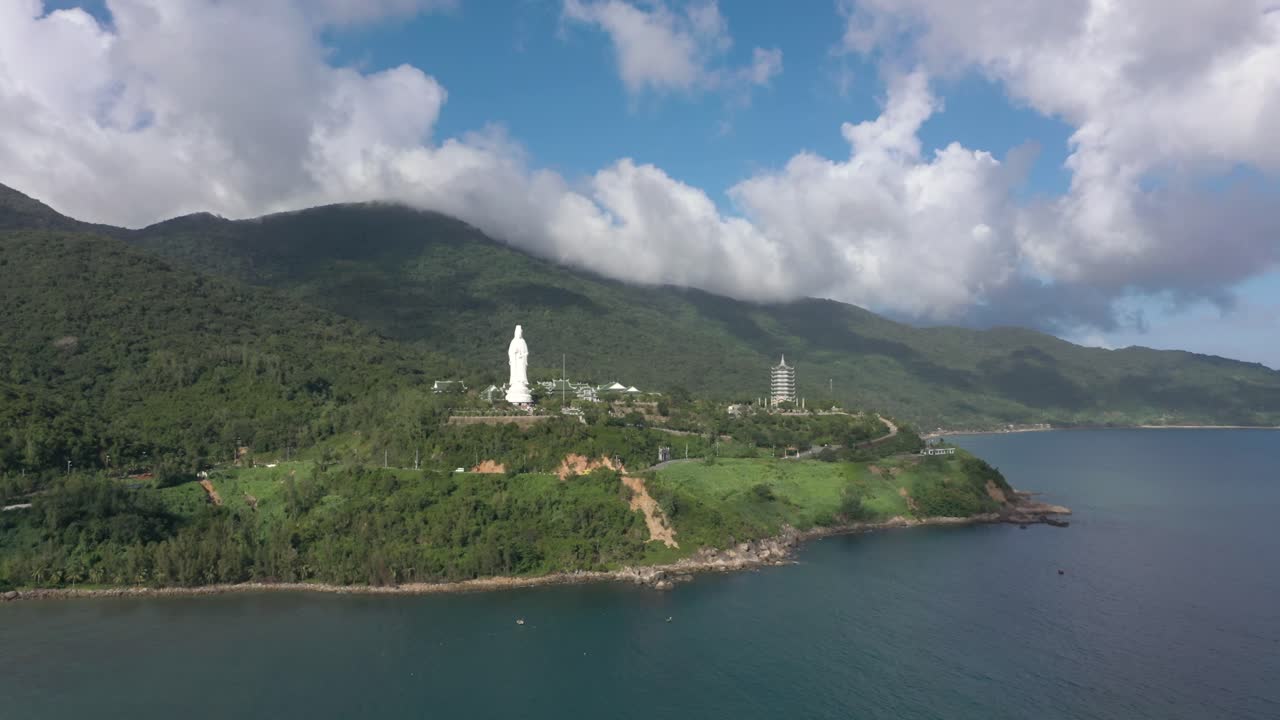 antena dando vueltas alrededor de la estatua de buda y templos con enormes montañas y océano en da nang, vietnam