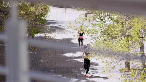 two fitness athletic friends jogging in the urban city from overhead