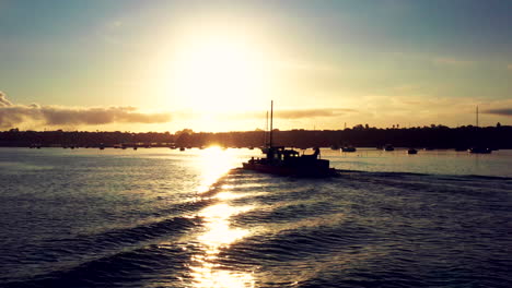 Aerial-sunset-landscape-view-above-sailing-ship-in-Auckland-port,-NZ