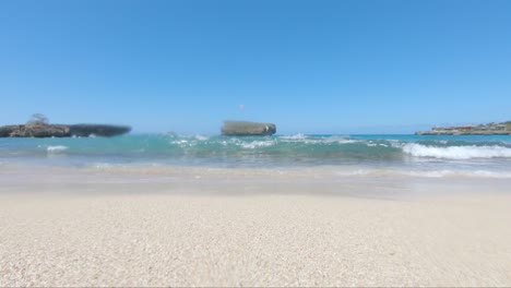 view from the shore in rio san juan dominican republic, waves hitting the go pro on a sunny day