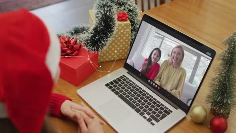 Mujer-Caucásica-Feliz-En-Videollamada-Con-Una-Amiga-Y-Su-Hija-En-Navidad