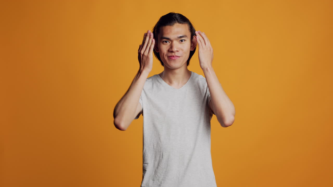 Confident hipster guy doing three wise monkeys sign