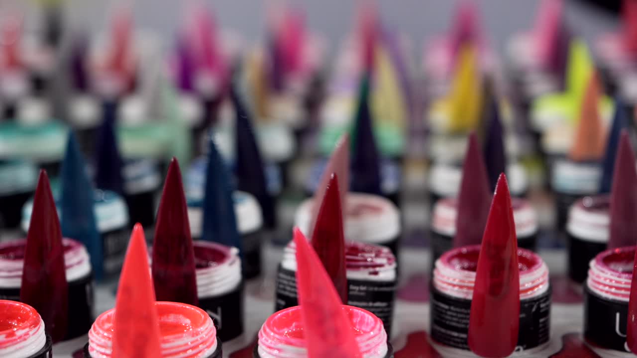 Bright gel nail colors in pointed samples neatly displayed in product rows