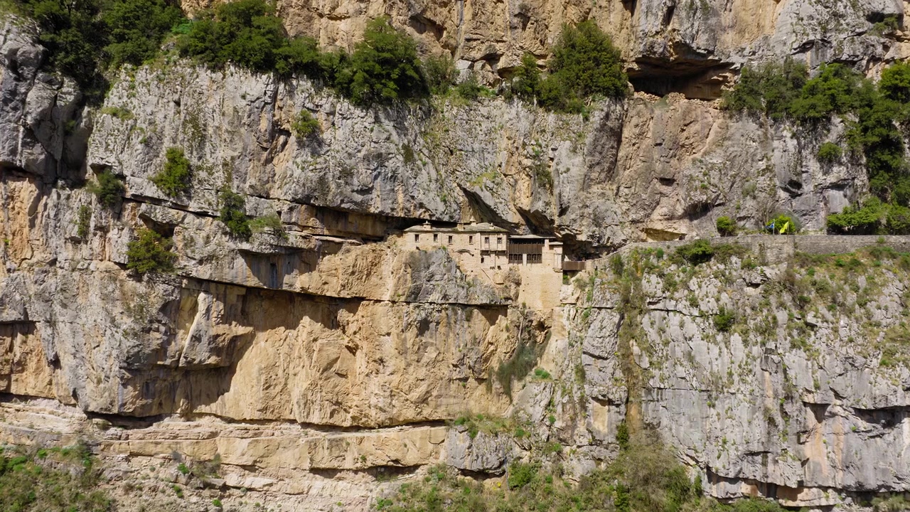 Monastero di Kipinas, Tzoumerka. Panoramica lenta con drone. Drammatico monastero costruito sulla scogliera circondato da montagne aspre. Cielo coperto. Epiro, Grecia, vista aerea