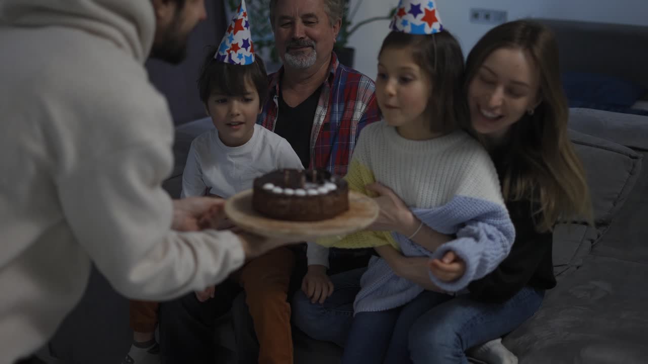 el hermano pequeño y la hermana soplan las velas en el pastel juntos en un círculo de familia feliz