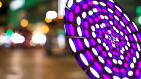 Animation-of-globe-made-of-purple-lights-rotating-over-blurred-night-cityscape