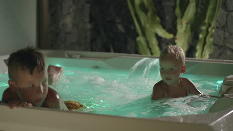 brother looking after junior sister when bathing in hot tub