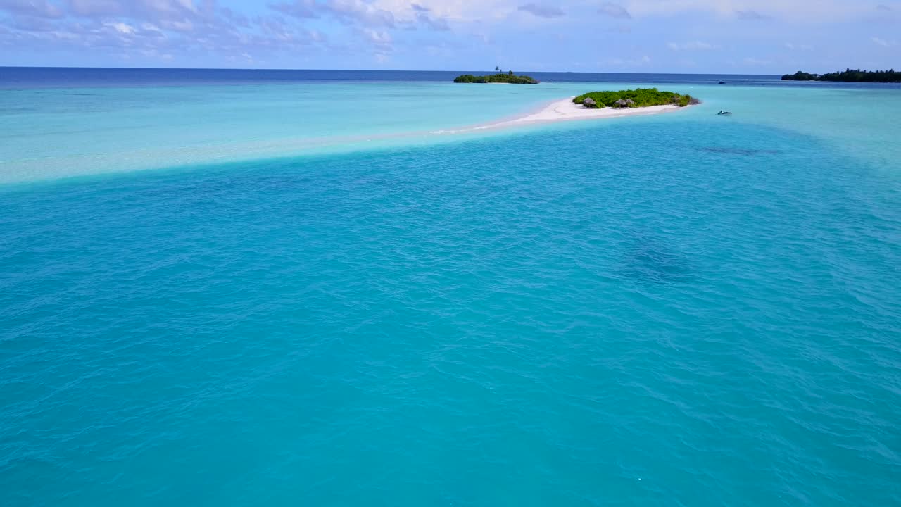 Tranquil azure water in the middle of turquoise lagoon close to tiny tropical islands with lush vegetation on a bright sky background in Caribbean