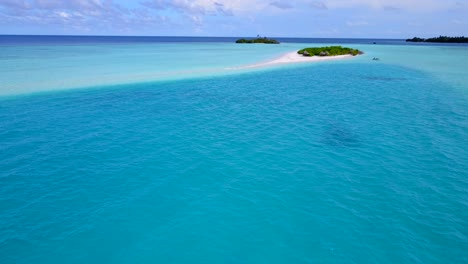 tranquil azure water in the middle of turquoise lagoon close to tiny tropical islands with lush vegetation on a bright sky background in caribbean