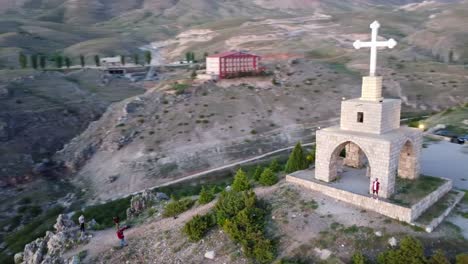 aerial view of a stone church on a mountaintop at sunset