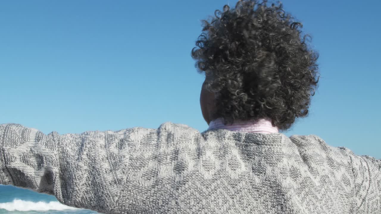 해변에서 팔을 들고 있는 고령 여성