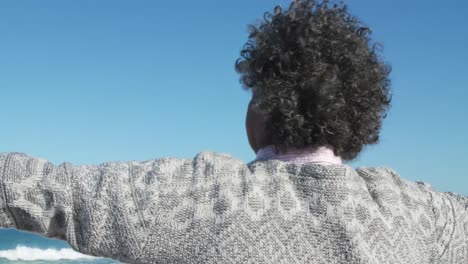 mujer mayor levantando los brazos en la playa