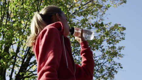 runner woman drinking water bottle sun flare solar energy