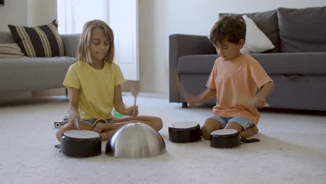 exited girl and boy knocking on pans and having fun