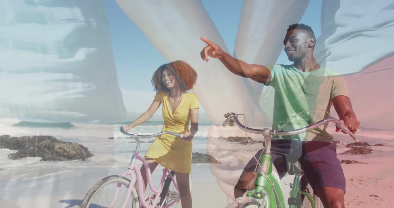 Couple riding pink or green bikes hands overlay appearing, causing she laughing he pointing for trav