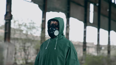 man in gas mask and protective clothing. man in gas mask and cloak for chemical protection on abandoned factory