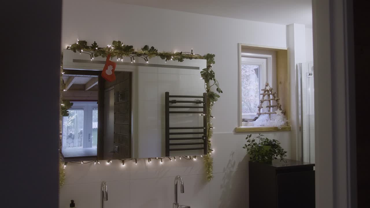 산타 클로스는 거울에서 자신을 지켜보고 수염을 만진다