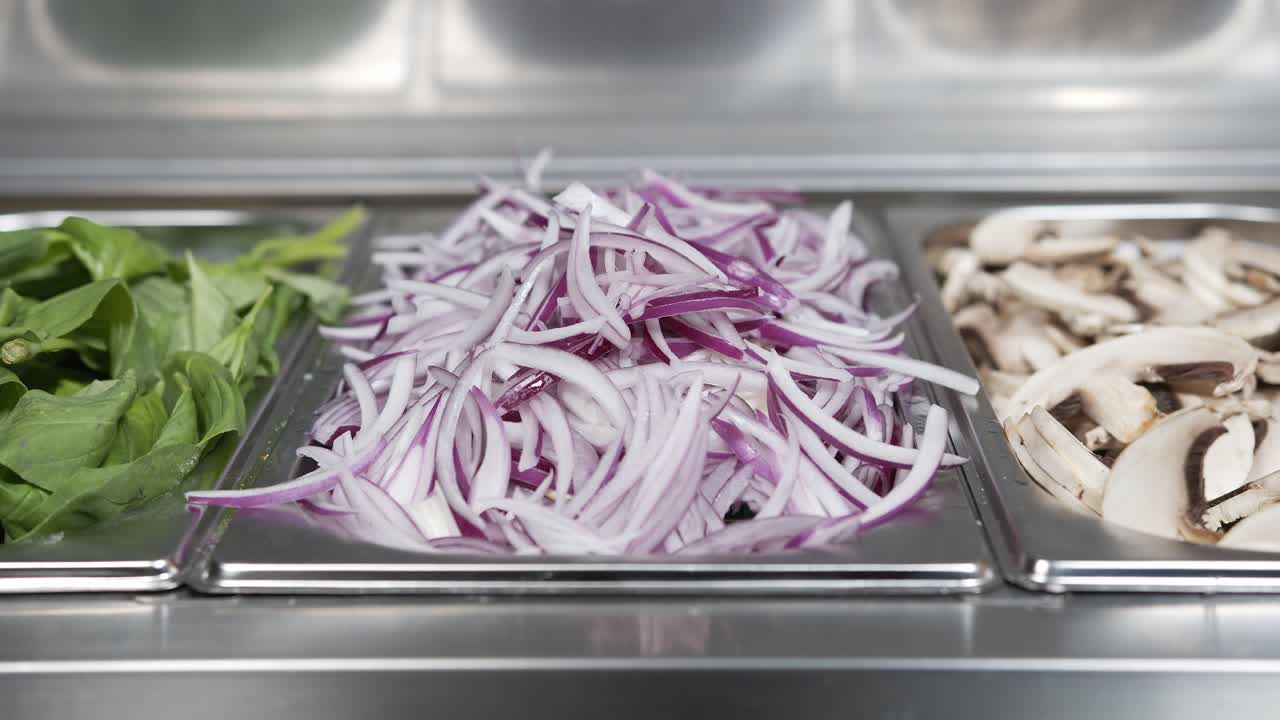 close-up of a mozzarella sprinkled over a juicy red tomato sauce on pizza dough