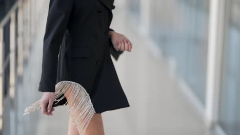 그녀의 손에 핸드백과 마른 여자에 세련된 검은 드레스의 근접