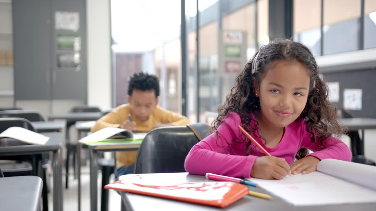 In school, young biracial girl focusing on drawing in the classroom with copy space