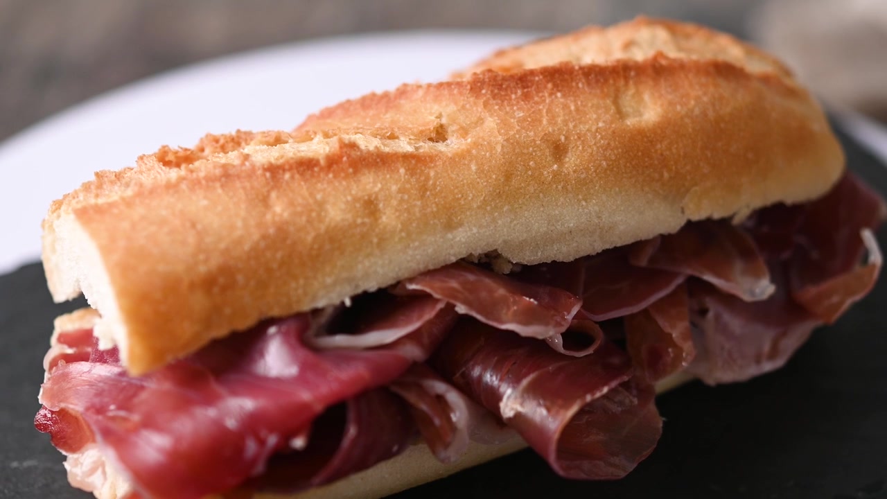 Panino con prosciutto serrano spagnolo su tavolo di legno. Bocadillo de jamón serrano spagnolo