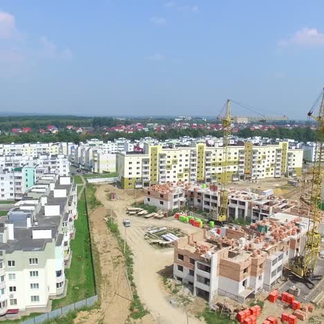 builders are working on the construction of modern high-rise buildings on the background of the city. aerial view