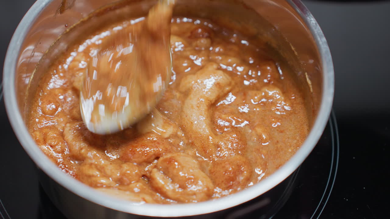 Close-up of person stirring thick, creamy pap in a pot on an electric stove, the texture changes as it is mixed, the steam rises, showing the heat of the cooking