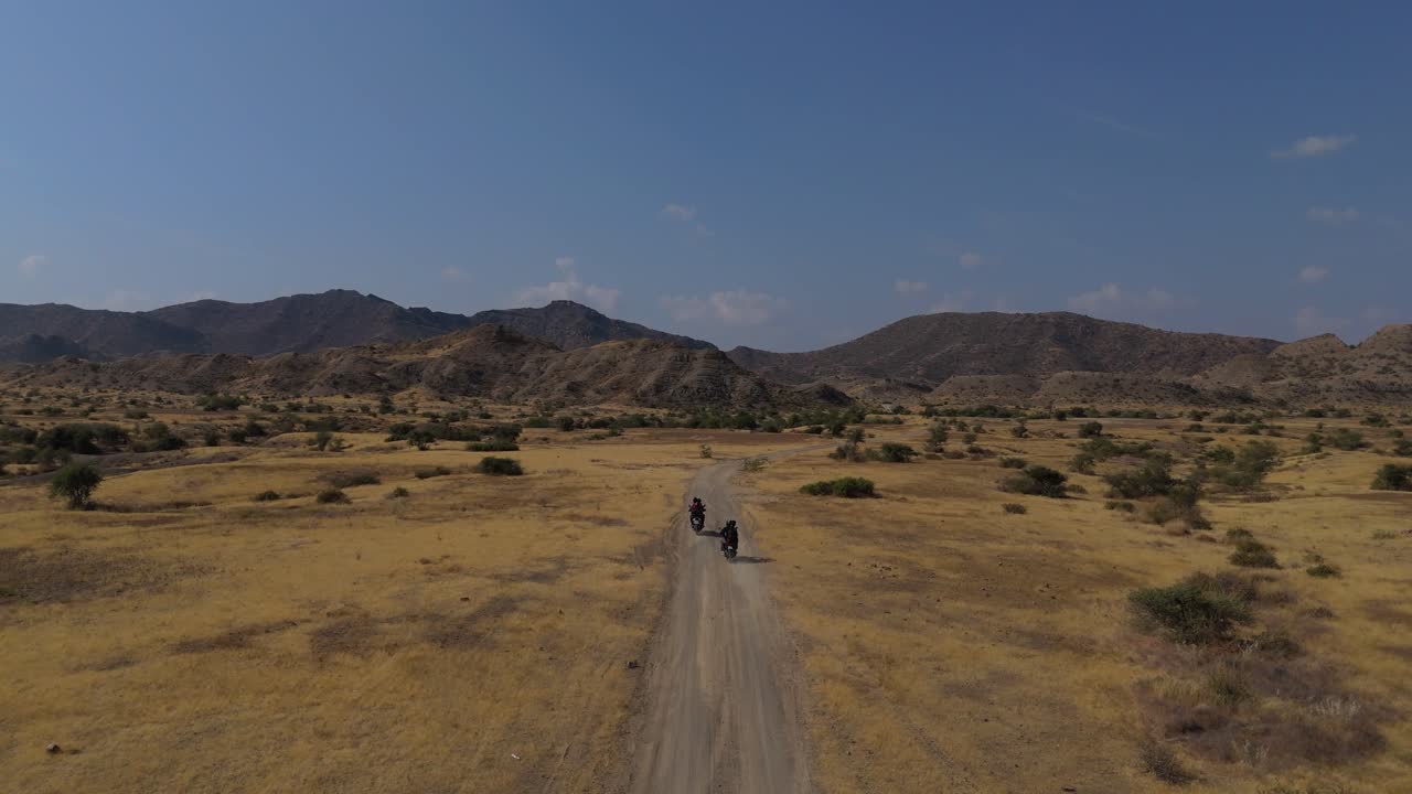 Persone in moto nel deserto della Valle di Kanraj in Pakistan.