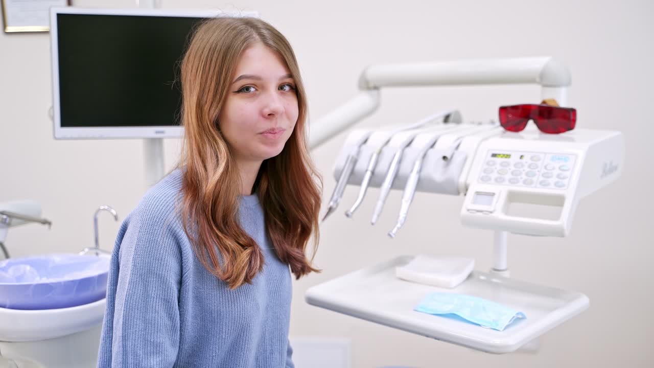 Young woman eats an apple in modern dental clinic. Healthy teeth concept. Solving sensitive teeth problem.