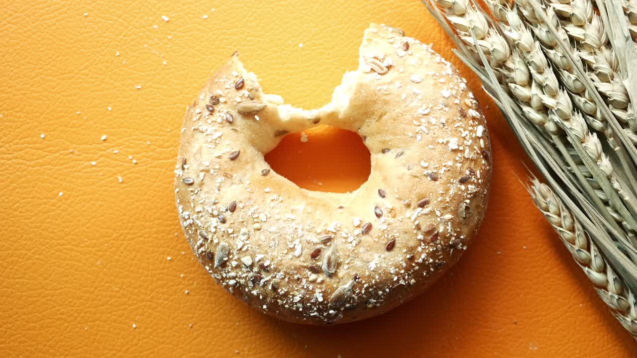 bagel comido a mitad de fondo naranja
