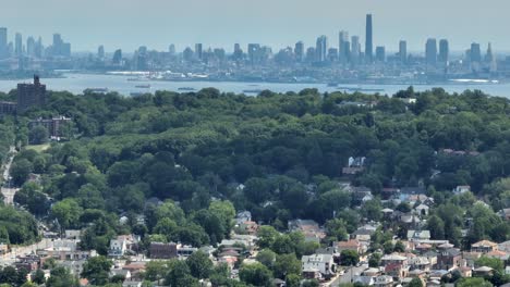 tomada panorámica de avión no tripulado del distrito suburbano de staten island y el enorme horizonte de manhattan durante un día de niebla en el fondo - toma aérea con lente de zoom