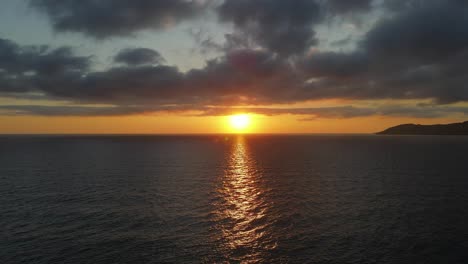 a beautiful, dramatic seascape sunrise over calm water. stunning cloudscape ocean horizon.