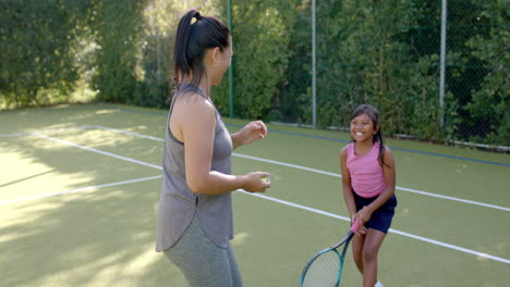 playing tennis, woman coaching young girl on court, enjoying outdoor activity