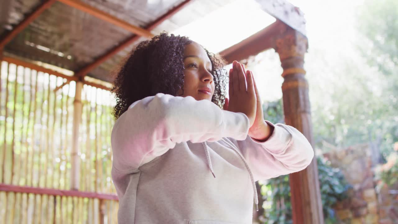 Afroamerikanische Frau, die im Ferienhaus Yoga praktiziert und meditiert.