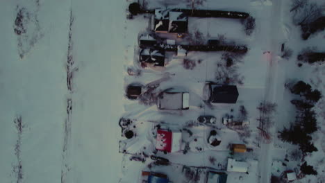 Vista-De-Pájaro-Desde-Un-Ahogado-Volando-Sobre-Casas-Junto-A-Un-Lago-Congelado-Durante-El-Invierno-En-Canadá