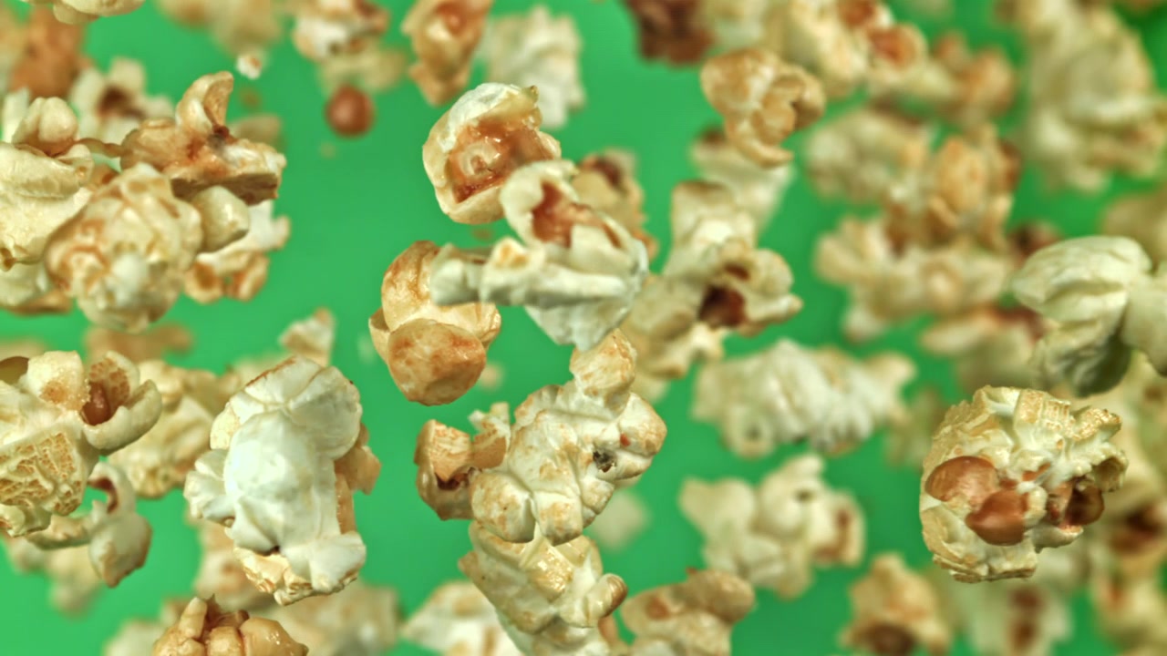 Close-up of Popcorn Falling in Slow Motion on Green Screen