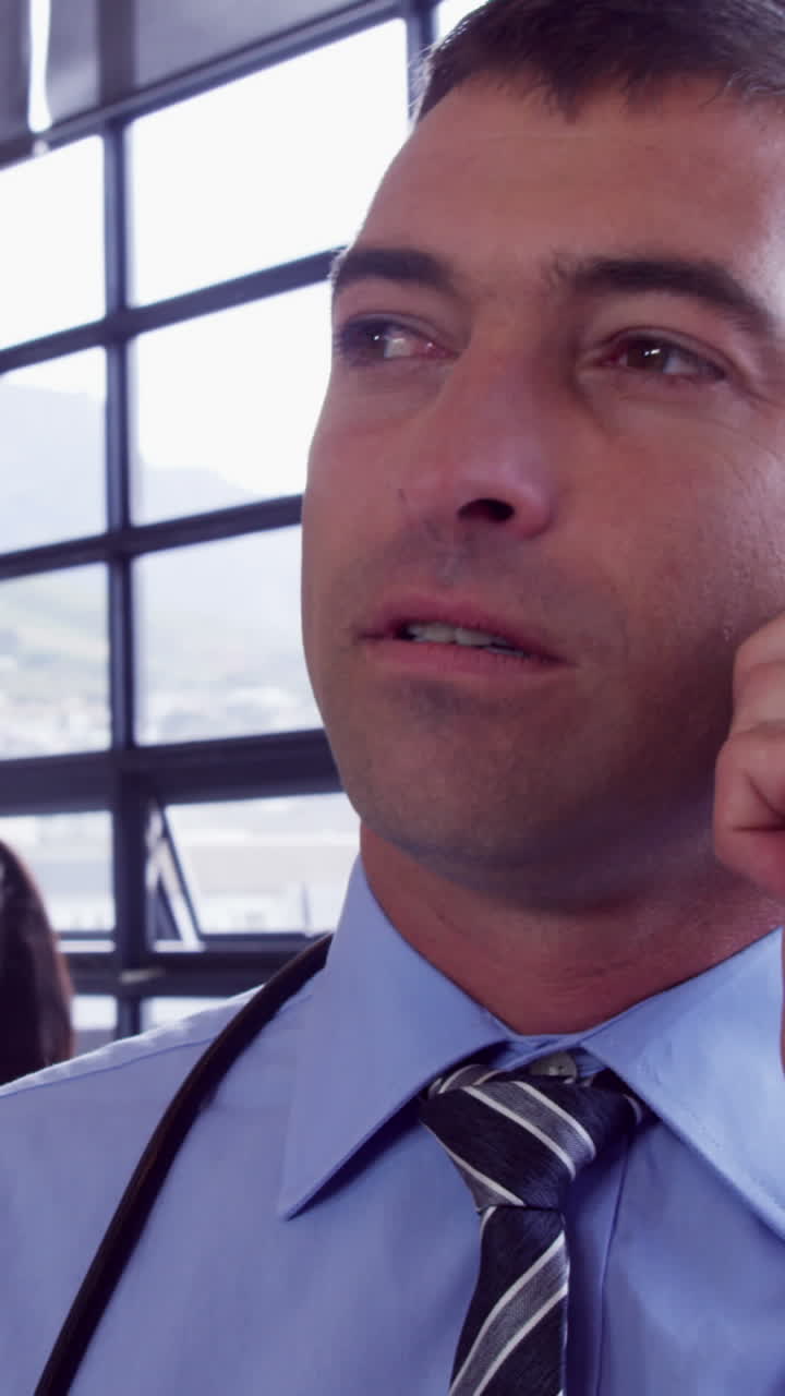 médico masculino haciendo una llamada telefónica mientras los médicos femeninos charlan